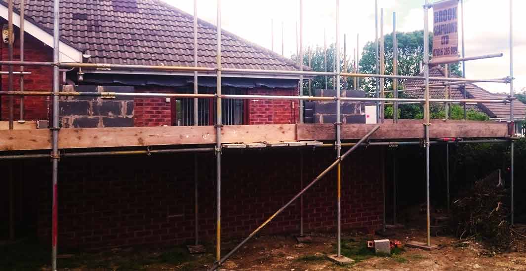 distance view of brook scaffoldings home scaffolders erecting scaffold around a rotherham brick built residential house