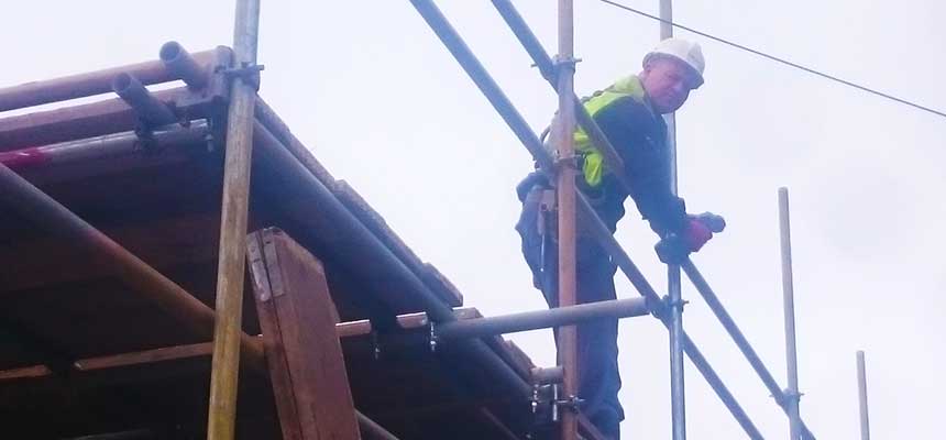 a brook scaffolder scaffolder working at the very top of 3 storey building